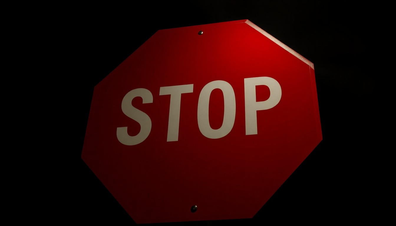 An extreme close-up photograph of a crossing guard's stop sign, lit by a harsh, direct camera flash against a pitch-black background, capturing the stark, gritty reality of the hazardous conditions crossing guards face in this community.