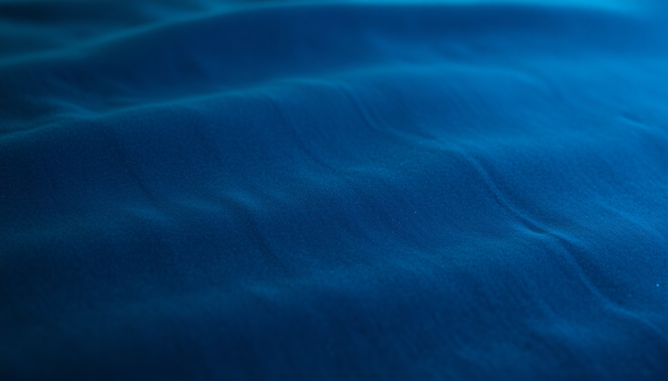 An abstract, close-up photograph of a luxurious, plush velvet fabric in rich, jewel-toned hues of emerald green and royal blue, capturing the high-end, teen-inspired design aesthetic of the HGTV Smart Home guest bedroom.