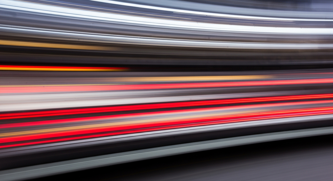 An abstract, motion-blurred image of a car in vibrant shades of red, orange, and yellow, conveying a sense of speed and energy.