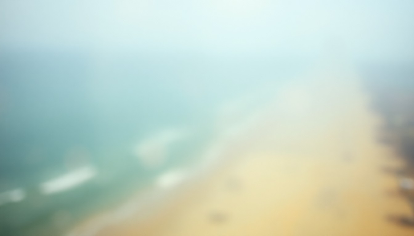 An extremely blurred, out-of-focus aerial photograph in warm, hazy tones, capturing the soft, atmospheric essence of a coastal beach landscape.