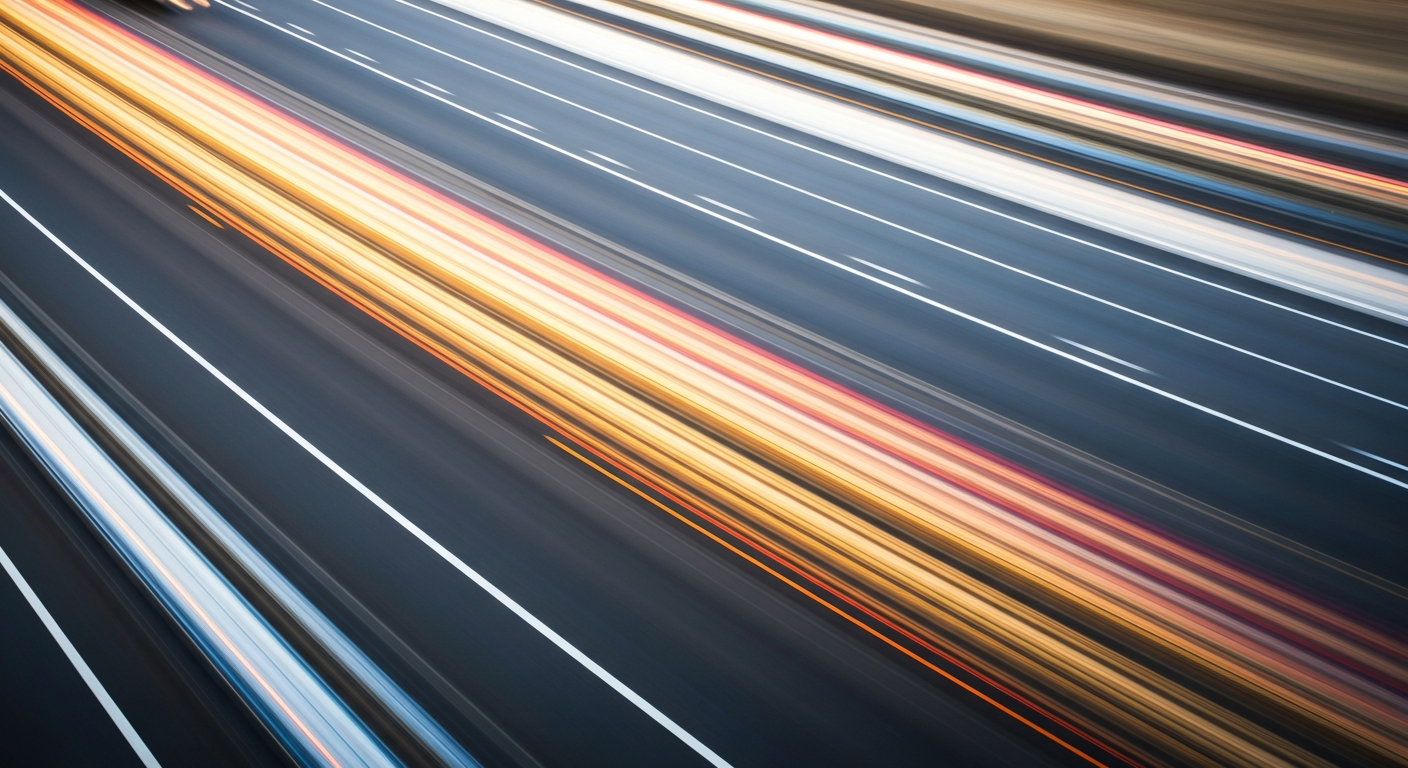 An abstract, colorful image created with a slow shutter speed and panning motion, depicting a blurred vehicle on the highway to convey the speed and energy of the I-70 overhaul project.