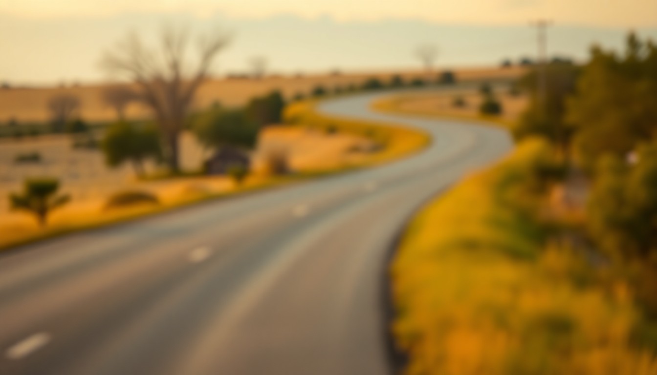 An extremely abstracted, out-of-focus photograph of a winding rural road, with soft pools of warm light and color creating an atmospheric, dreamlike quality that conceptually represents the transportation challenges and community concerns along the FM 969 corridor in Central Texas.