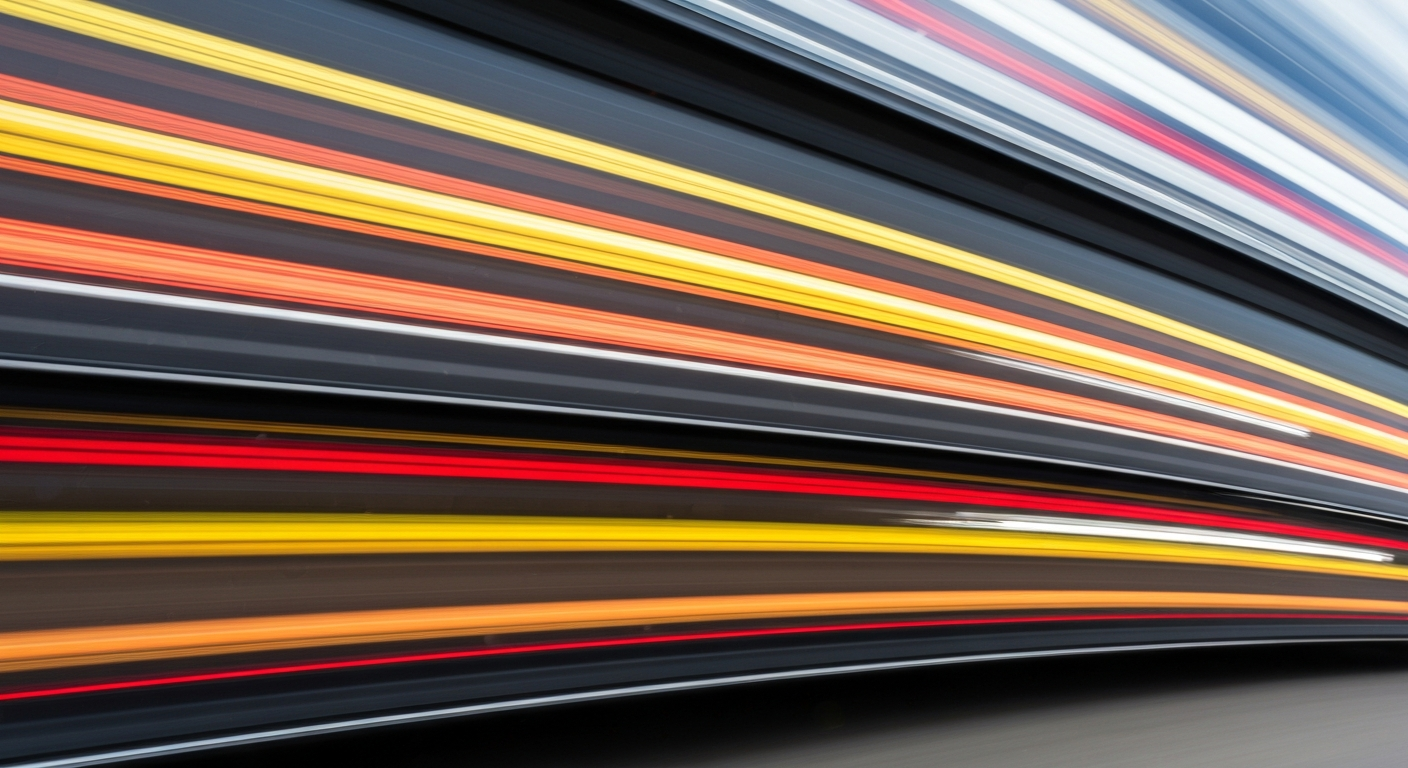 An abstract, colorful image featuring sweeping brushstrokes and blurred lines, conveying a sense of speed and movement without any identifiable vehicles or people.